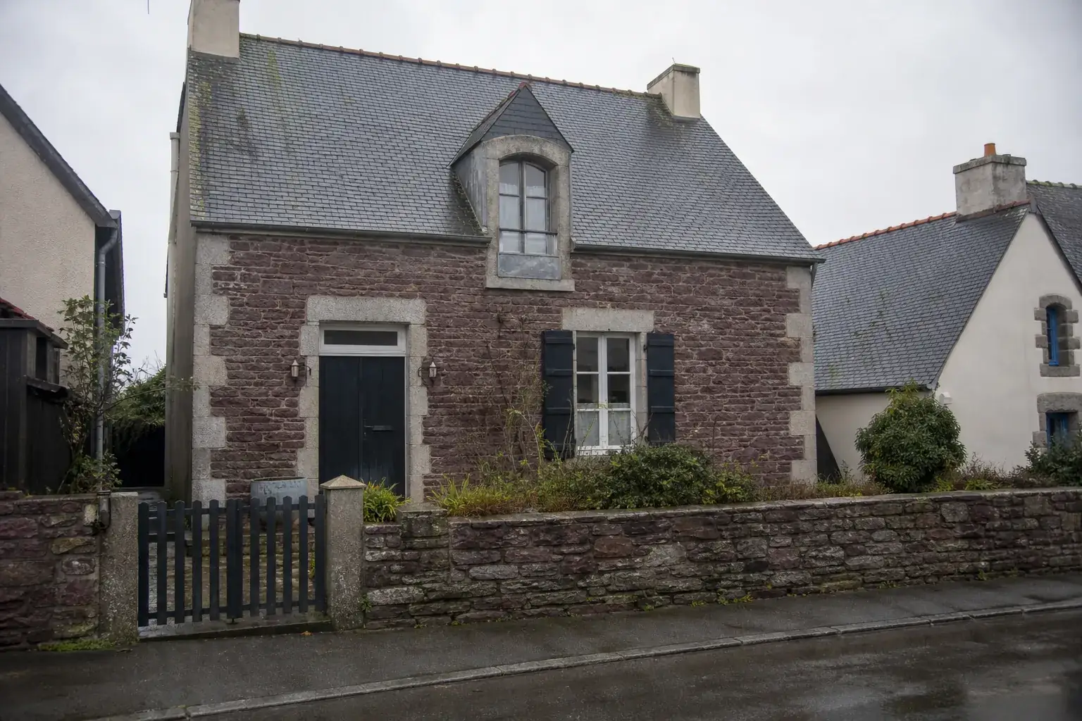 Maison de bourg en moellons de schiste pourpré avec chaînages de granit, toit d’ardoise à forte pente et une lucarne